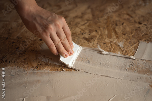 Canvas Print Hand applies the putty with a spatula