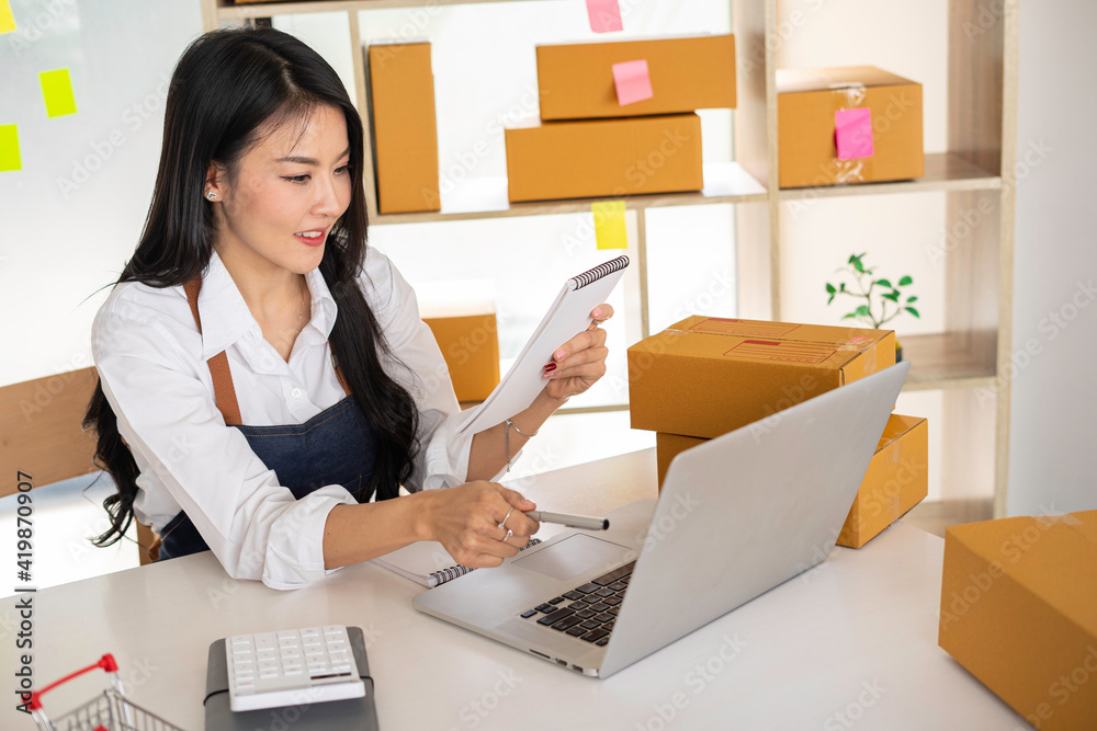 Starting small businesses SME owners female entrepreneurs Use a laptop or notebook to receive and review orders online to prepare to pack boxes, sell to customers, online sme business ideas. Starting small businesses SME owners female entrepreneurs Use a laptop or notebook to receive and review orders online to prepare to pack boxes, sell to customers, online sme business ideas.