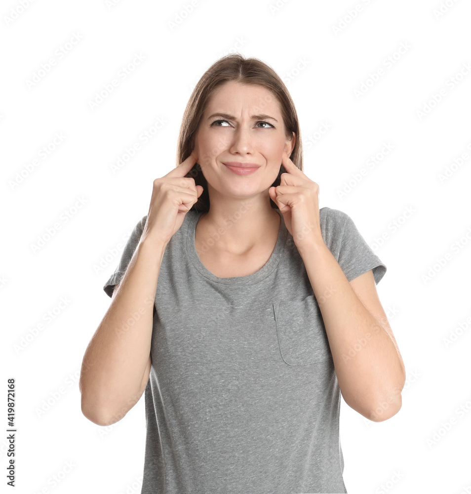 Emotional young woman covering her ears with fingers on white background Emotional young woman covering her ears with fingers on white background