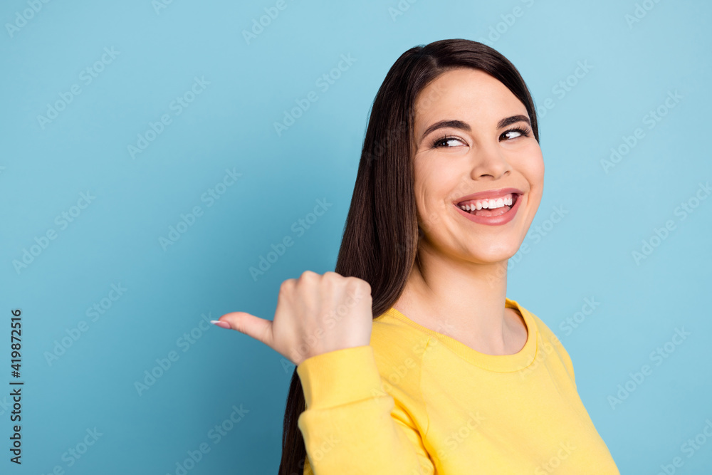Profile portrait of nice optimistic brunette long hairdo lady look point empty space wear yellow shirt isolated on bright blue color background Profile portrait of nice optimistic brunette long hairdo lady look point empty space wear yellow shirt isolated on bright blue color background