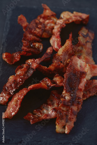 fried bacon on black surface