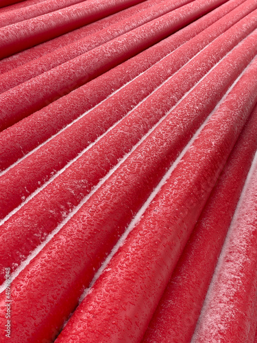 Red pipes stacked in a factory.