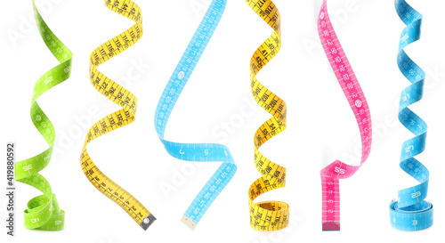 Set with different measuring tapes on white background