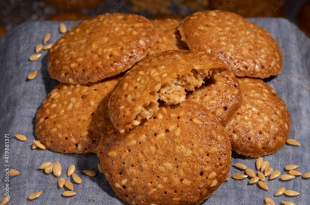 A pile of sesame cookies on a gray canvas napkin A pile of sesame cookies on a gray canvas napkin