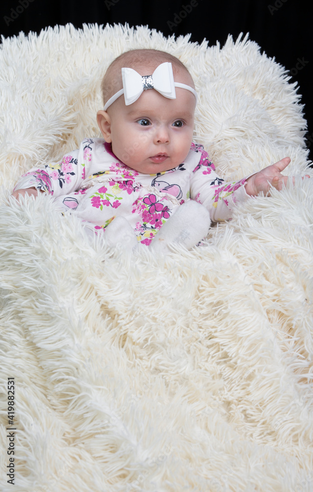 Beautiful baby in a fur blanket. The girl is four months old. Children under one year old. Beautiful baby in a fur blanket. The girl is four months old. Children under one year old.