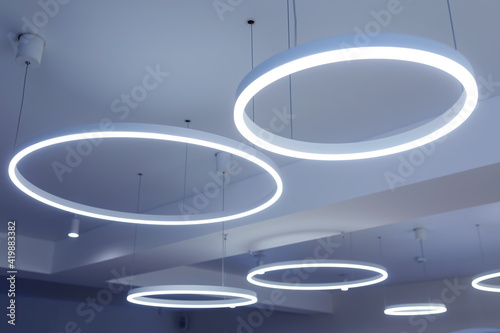 Ceiling with round modern LED lamps. Suspended fluorescent lights under the ceiling. Careful energy consumption, energy saving concept photo