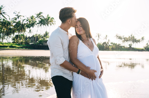 Loving husband kissing pregnant wife on beach © BullRun