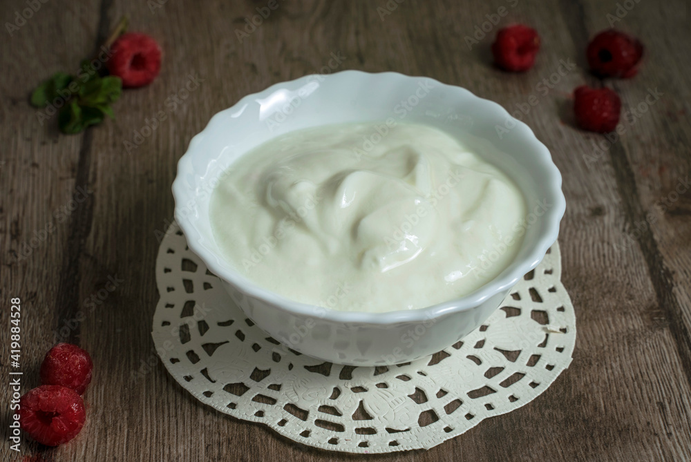 homemade yogurt in a white bowl on a wooden table homemade yogurt in a white bowl on a wooden table