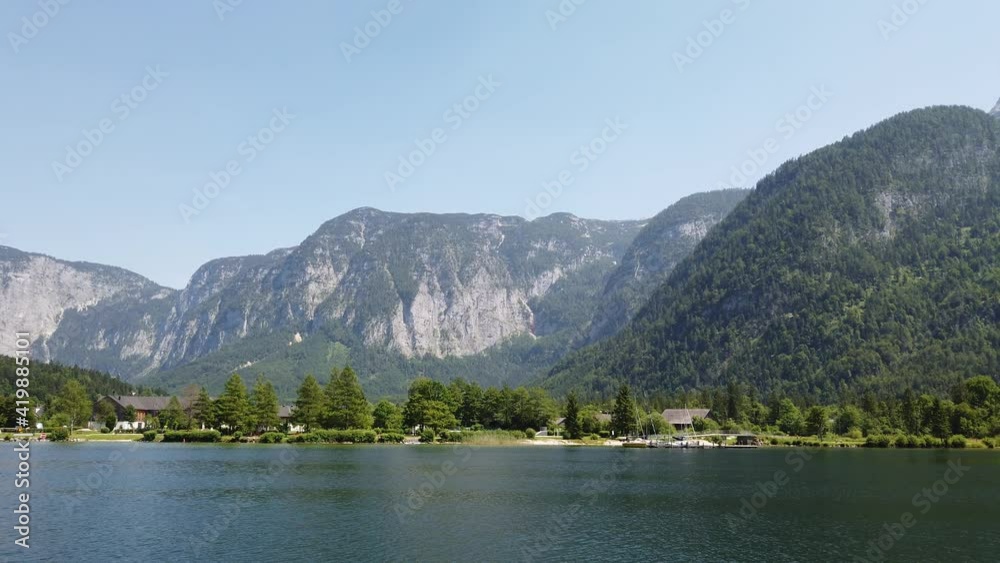 Summer rural landscape with lake and houses by blue sky in Hallstatt, Upper Austria. European alps and Hallstatter lake in Salzkammergut region Summer rural landscape with lake and houses by blue sky in Hallstatt, Upper Austria. European alps and Hallstatter lake in Salzkammergut region