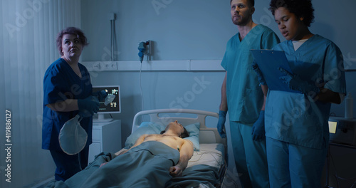 Quadro su tela Young male patient dying in emergency room surrounded by medical team
