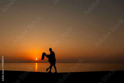 Silhouette of two young people on the beach in sunset