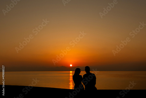 Silhouette of two young people on the beach in sunset