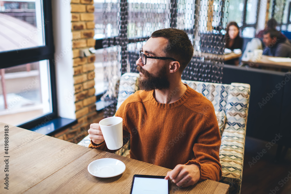 Thoughtful man spending time in cafe with tablet Thoughtful man spending time in cafe with tablet