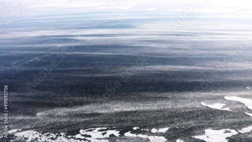 Heavy snowstorm drives snow across the frozen surface of Lake Baikal, Russia
