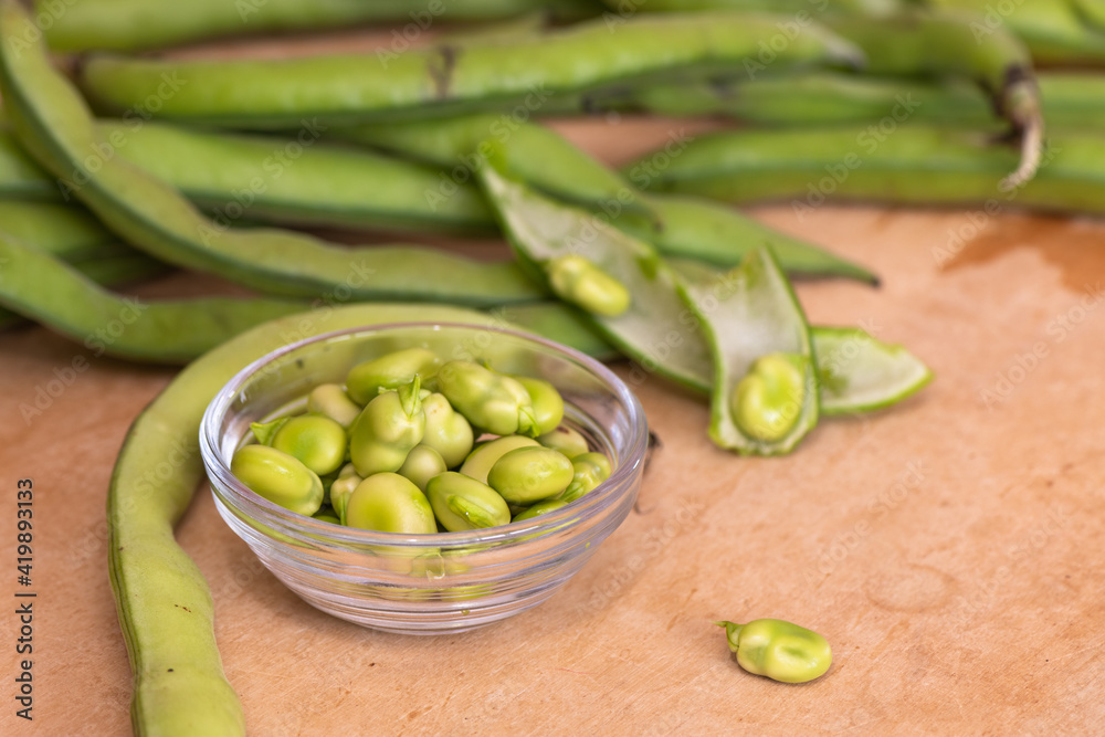 Fava beans on a wooden kitchen table Fava beans on a wooden kitchen table