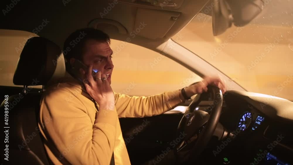 A man is talking on the phone while driving a car. He drives vehicles in the tunnel, transmits verbal messages using mobile internet.