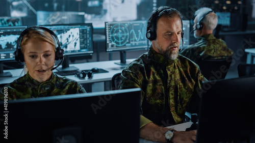 Obraz na plátne Military Surveillance Team of Officers in Headsets Working in a Central Office Hub for Cyber Operations, Control and Monitoring for Managing National Security, Technology and Army Communications