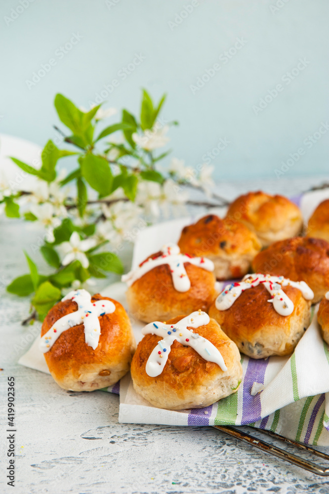 Homemade Easter traditional hot cross buns and painted eggs on a gray background