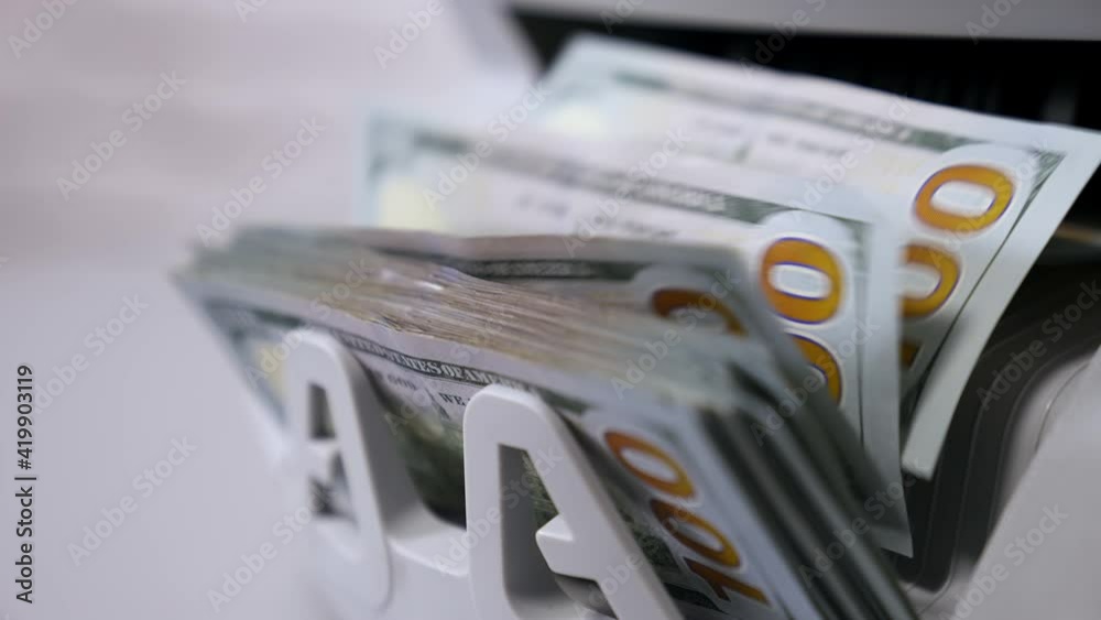 Automatic calculation of paper money. Detailed view of Us dollar banknotes on currency counter machine. Business economy of usa. Macro shot.