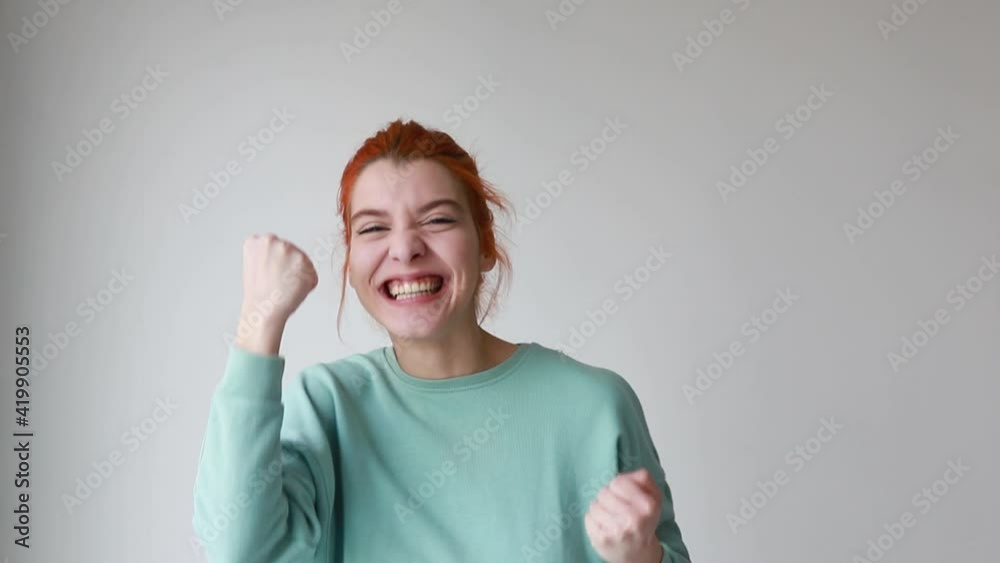 Young girl looking happy showing yes gesture and rejoicing on camera over white background. Winner expression Young girl looking happy showing yes gesture and rejoicing on camera over white background. Winner expression