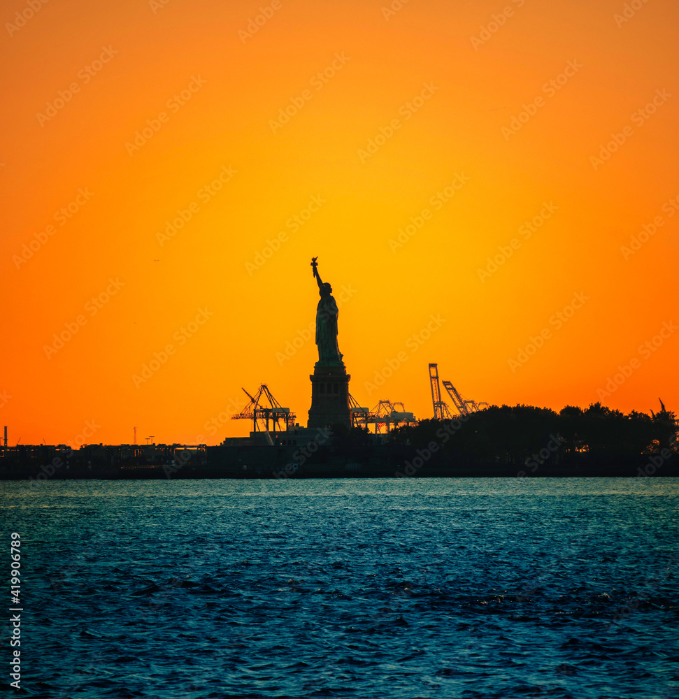 statue of liberty at sunset beautiful sky color orange sea blue 