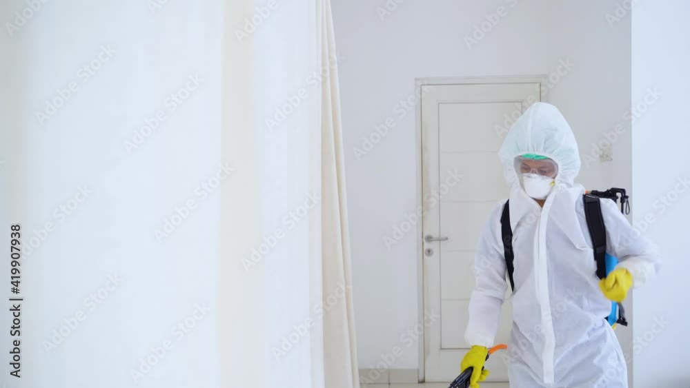 Worker clean interior house with disinfectant spray Worker clean interior house with disinfectant spray