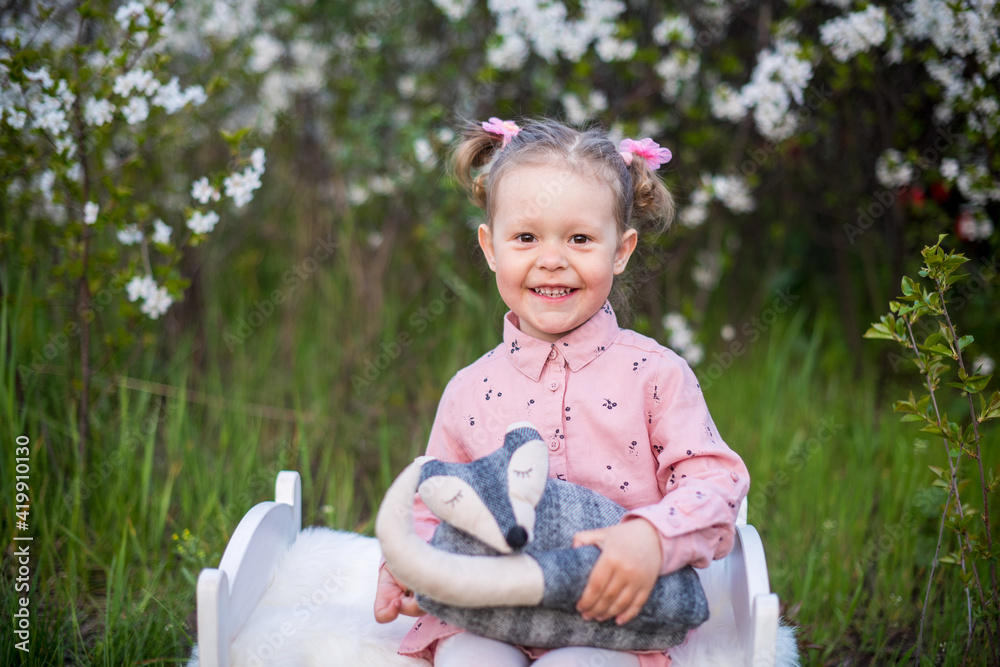 Emotion pretty toddler girl in the blooming park .Girl in pink dress. Close up. Copy space. Spring time. Blossoming background. Emotion pretty toddler girl in the blooming park .Girl in pink dress. Close up. Copy space. Spring time. Blossoming background.