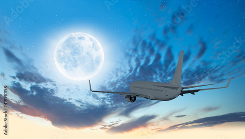 Fototapeta Naklejka Na Ścianę i Meble -  Passenger airplane in the sky on the background full moon at sunset 