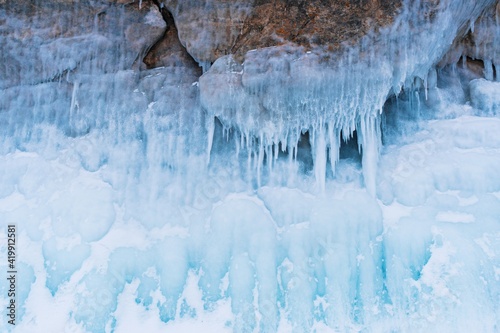 The texture of beautiful turquoise icicles cover the rock. Colored ice in a cave on Lake Baikal.