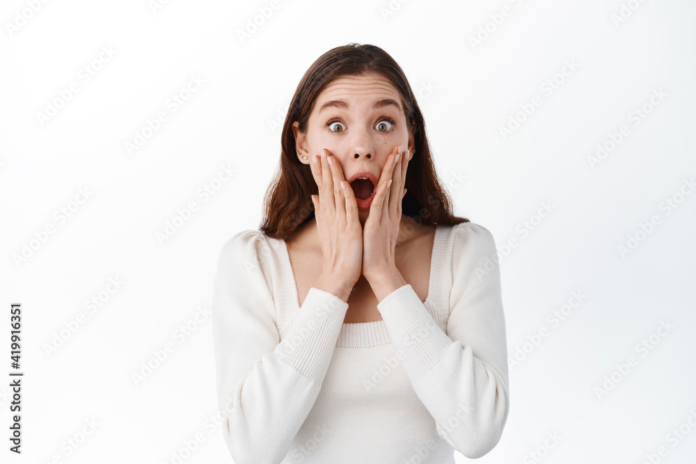 Shocked girl holding hands near opened mouth, stare fascinated with disbelief at lucky good news, stare amazed, winning and rejoicing,gasping impressed, white background Shocked girl holding hands near opened mouth, stare fascinated with disbelief at lucky good news, stare amazed, winning and rejoicing,gasping impressed, white background