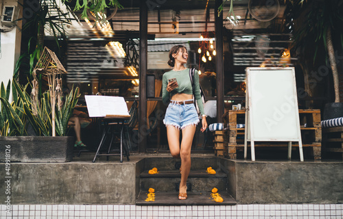 Foto Cheerful woman walking on stairs of cafe