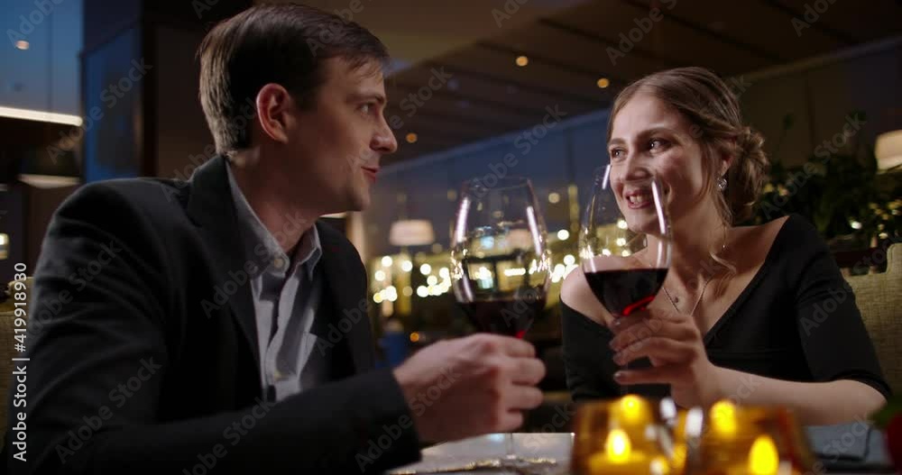 Caucasian couple on romantic date. Happy people are chatting during dinner in restaurant and drinking wine. Couple in love enjoying their time together 4k footage Caucasian couple on romantic date. Happy people are chatting during dinner in restaurant and drinking wine. Couple in love enjoying their time together 4k footage