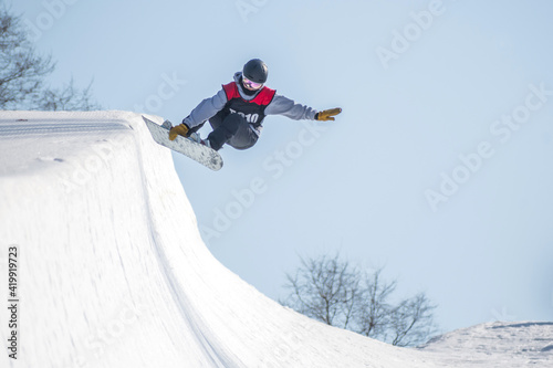 Vászonkép People are enjoying half-pipe skiing / snowboarding