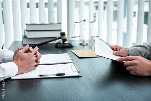 Tableau sur toile Male lawyer discussing negotiation legal case with client meeting with document