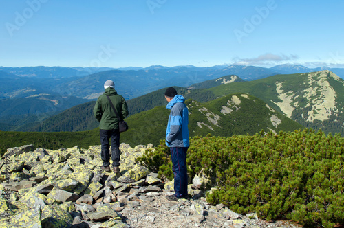 tourists on top of the mountain contemplate the majestic panorama of the valley
