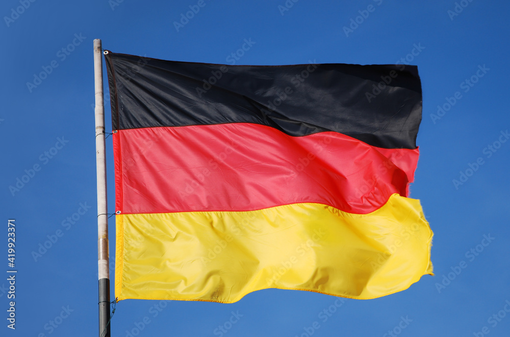 german flag waving in the wind in front of deep blue sky german flag waving in the wind in front of deep blue sky