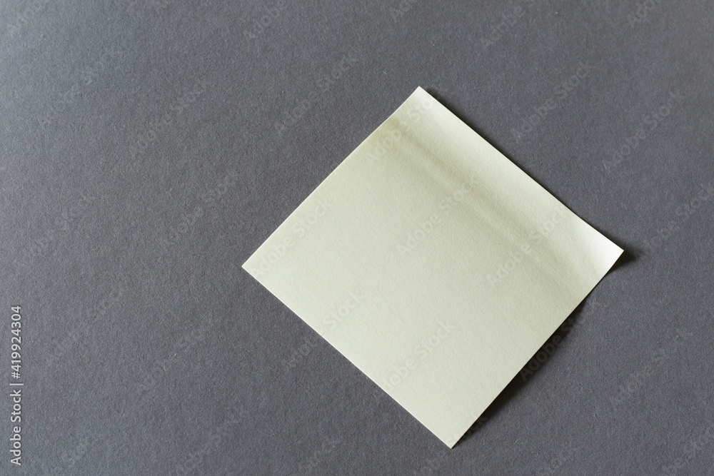 empty yellow memory sticky note on grey background empty yellow memory sticky note on grey background