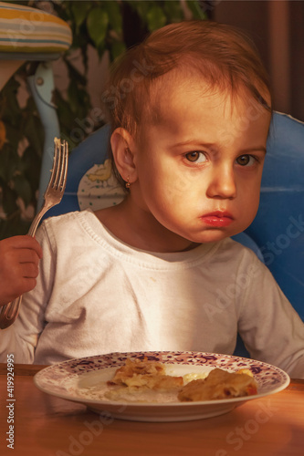 Funny image of little cute child girl with a fork. Selective focus.