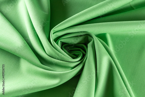 twisted in a spiral fabric of light green color for sewing clothes, background