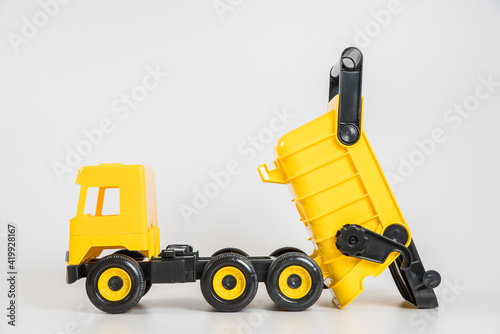Plastic car. Toy model isolated on a white background. Yellow truck.
