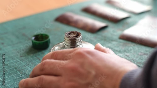Heating the tool for working with the genuine leather on the fire of an alcohol lamp.Tanner's hands close-up, slow motion.Handmade leather manufactures.Hobby concept.