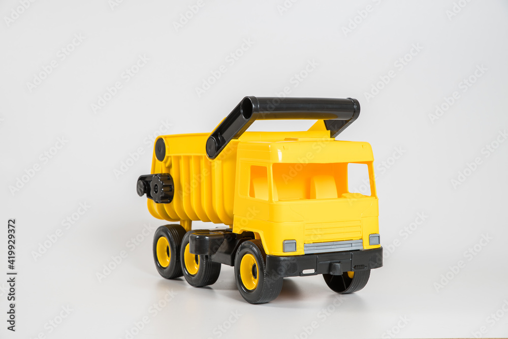 Plastic car. Toy model isolated on a white background. Yellow truck.