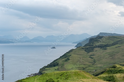 Scottish landscape with hills and shoreline near Staffin city  at Isle of Skye with green pastures