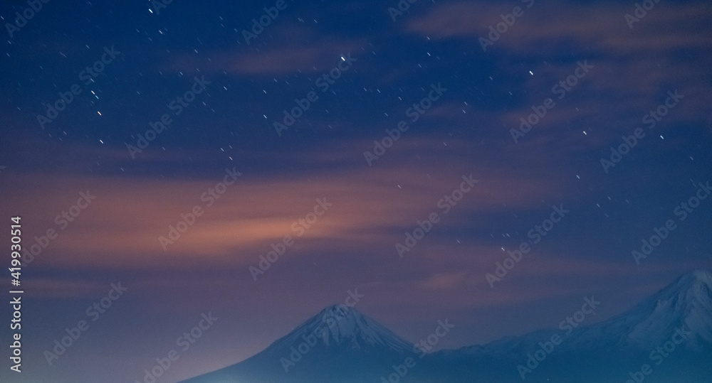 Ararat mountains in the night under the starry sky with clouds. Night sky background.  