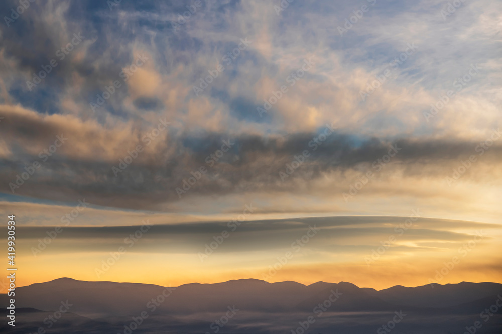 Beautiful panoramic view on the mountains silhouette on the sunset with bright clouds. Beautiful panoramic view on the mountains silhouette on the sunset with bright clouds.
