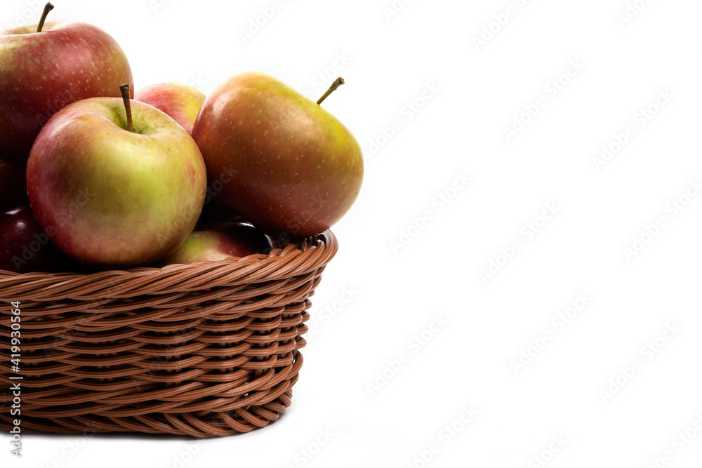 Wicker basket of fresh juicy apples isolated on white background Wicker basket of fresh juicy apples isolated on white background