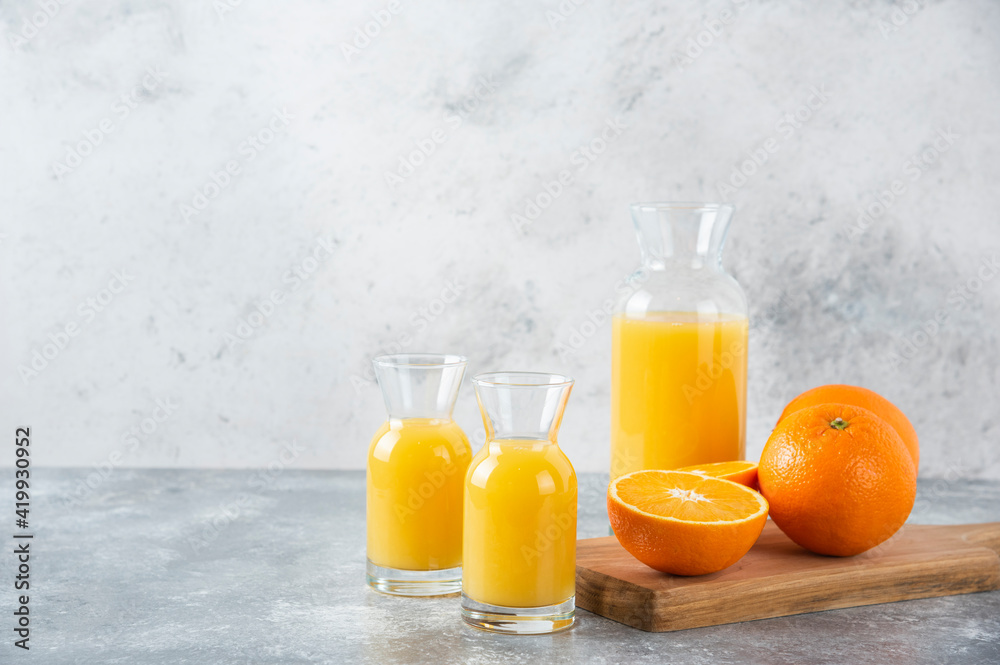 Glass pitchers of juice with slice of orange fruit Glass pitchers of juice with slice of orange fruit