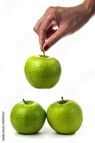 Woman hand holding green apples on white background