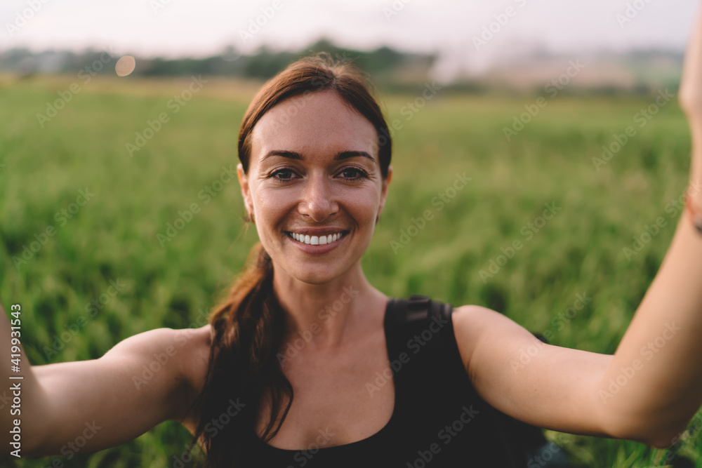 Woman taking selfie and looking at camera with toothy smile Woman taking selfie and looking at camera with toothy smile
