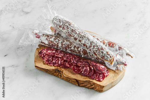 Italian salami on wooden deck on marble background. photo